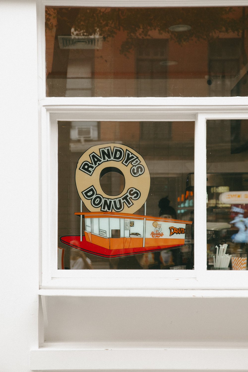 The Randy's Donuts logo sign in the Bleecker Street shop window