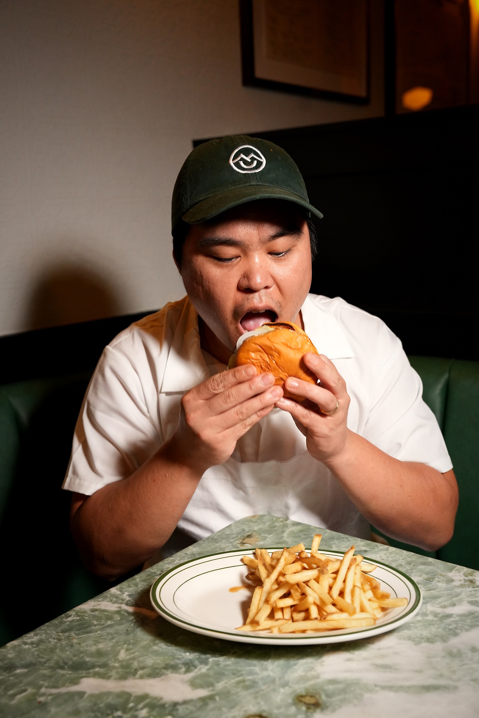 Chef taking a bite of the Susu's burger